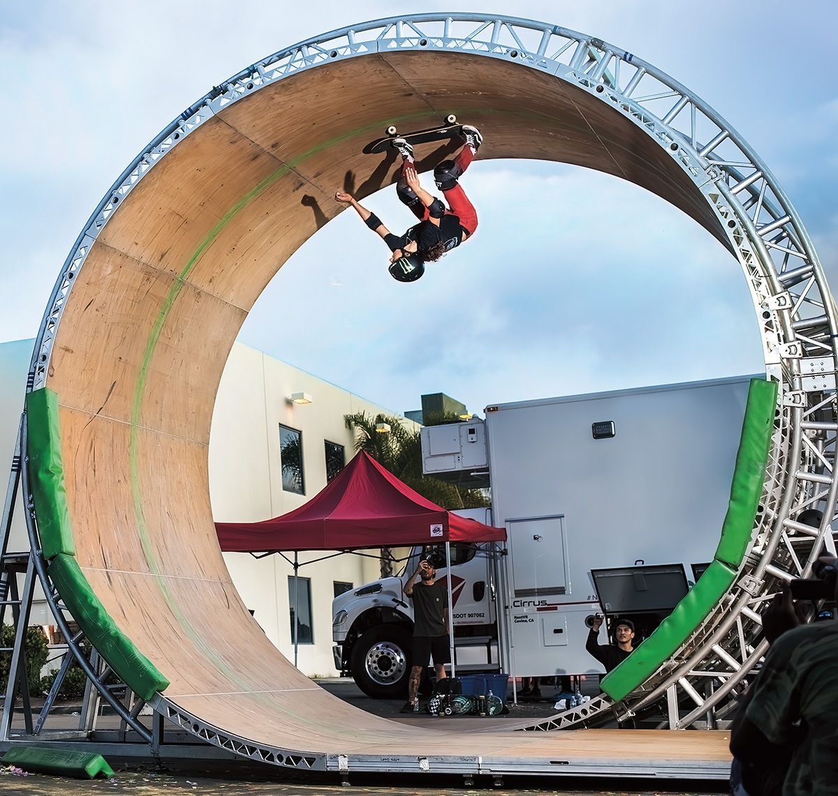 Photo of skateboarder upside down on a ramp while performing a trick