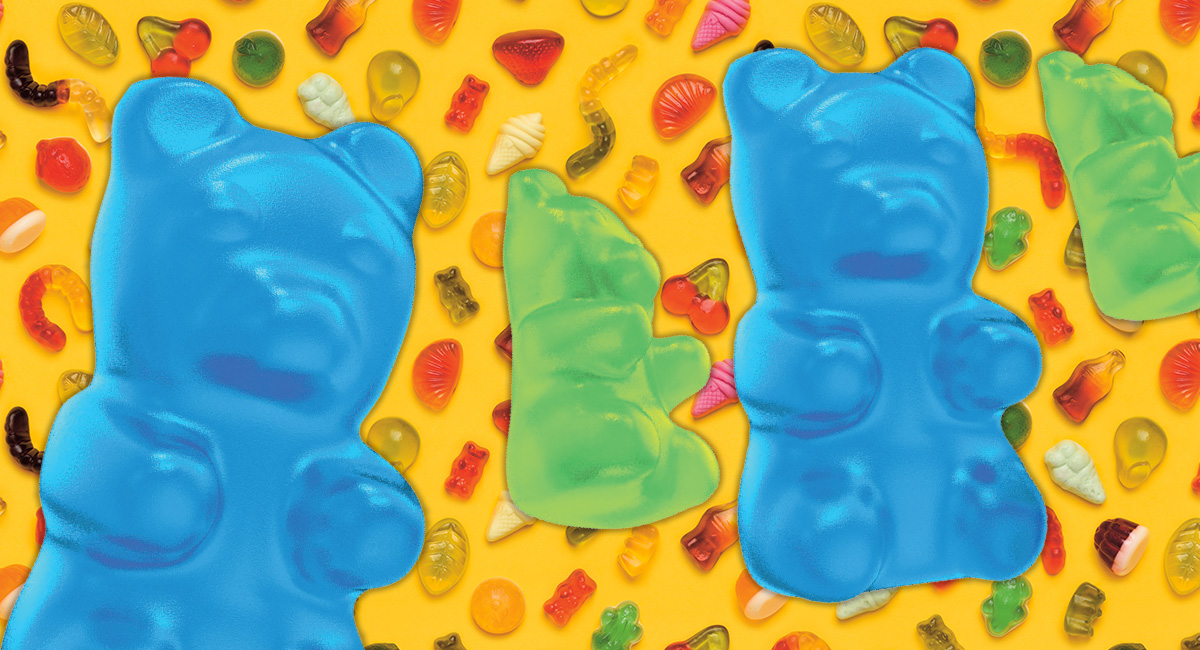 Image of two gummy bears in front of a variety of different gummy candy types